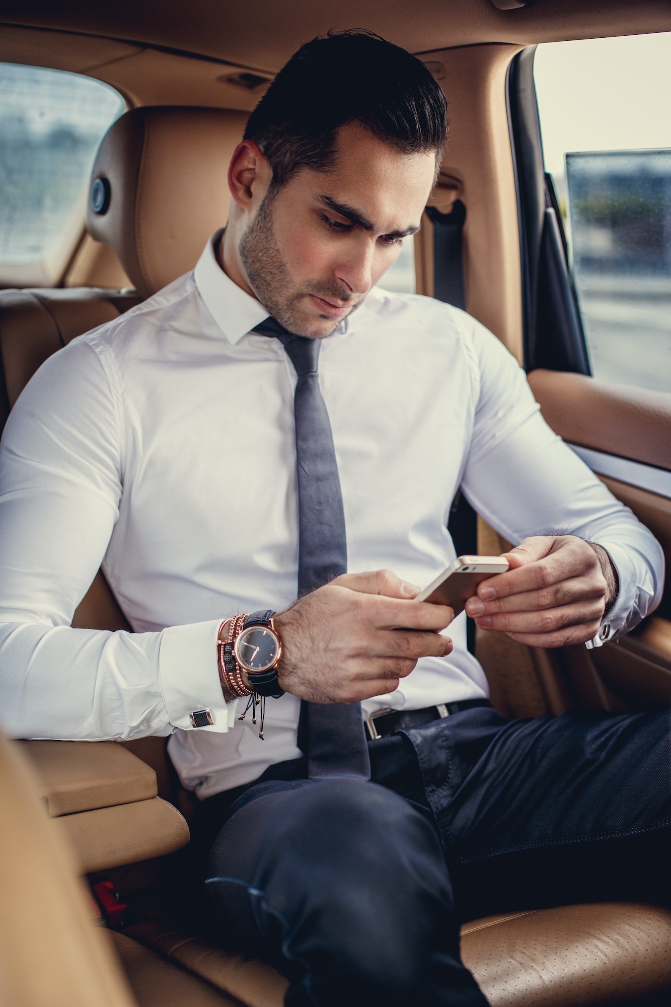 Stylish male in a white shirt using smartphone.
